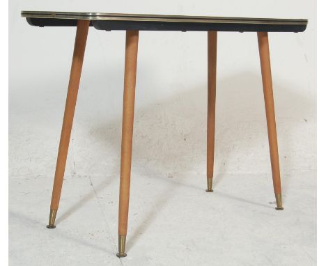 A vintage 20th century 1970’s low coffee table with marble effect top, gold colourway edge band raised on tapered supports wi