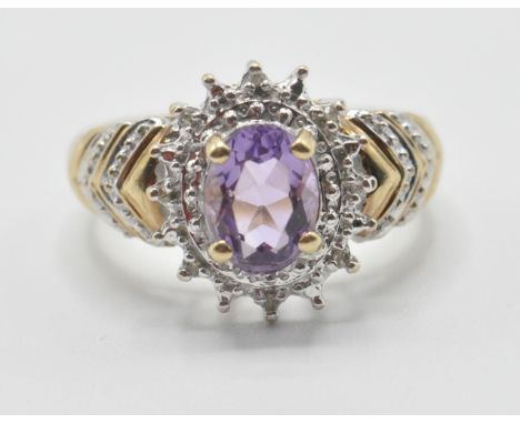 A ladies 9ct gold dress ring being set with an oval cut amethyst set with diamond accent stones with banded shoulders. Makred