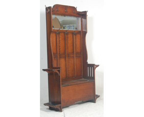 A Victorian 19th century oak hall stand settle. The hallstand with bench seat having a hinged lid flanked by umbrella stands 