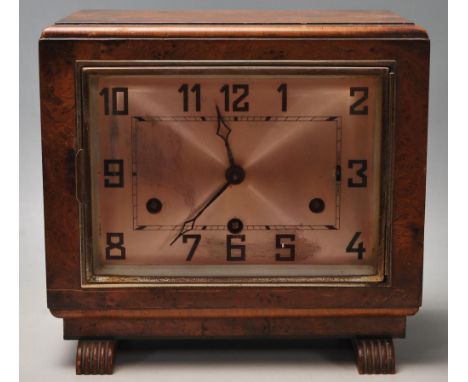 A vintage 1930's Art Deco mantle clock having a walnut case with a rectangular face and silvered dial with arabic numerals to