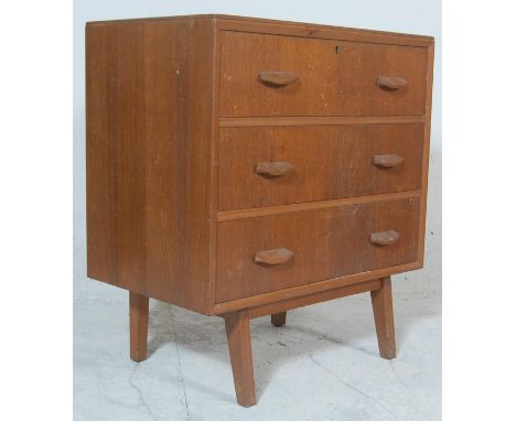 Gplan - Ernest Gomme. A retro vintage light oak chest of drawers having 3 drawers with shaped angular pulls raised on taperin