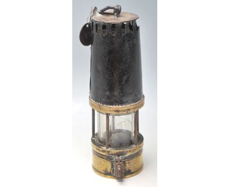 An early 20th Century Richard Johnson Clapham &amp; Morris Ltd miners lamp having a brass cylindrical body with original hook