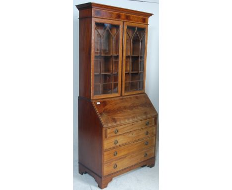 An Edwardian mahogany line inlaid bureau bookcase being raised on bracket feet with a chest of drawers beneath fall front bur