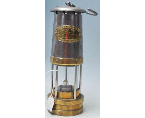 A early 20th century antique E. Thomas &amp; Williams Ltd miners safety lamp with metal and brass body. Makers plaque at the 