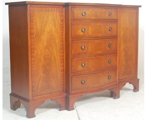 A Regency revival antique style mahogany breakfront bookcase. Raised on bracket feet with a series of cupboards having short 