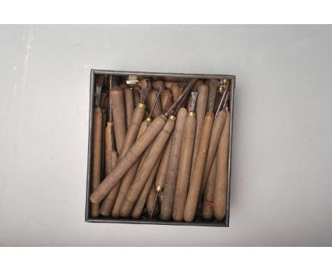 A set of retro vintage leather working / carving tools of various shapes and sizes all having wooden handles and metal edges.