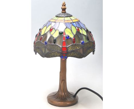 A contemporary antique style antique Tiffany lamp having a round gilt base with a leaded coloured glass shade decorated with 