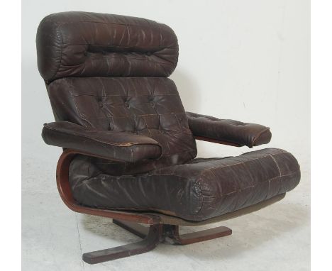 A mid century retro Danish inspired leather patchwork swivel chair - easy armchair. Raised on 4 point base with overstuffed l