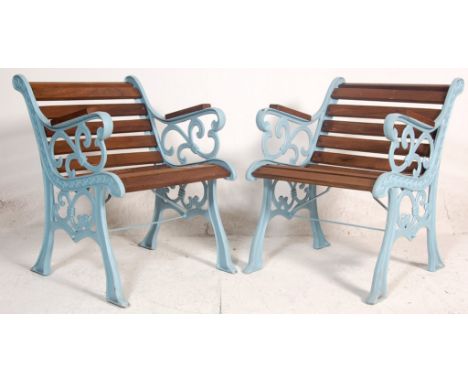 A pair of late 20th Century Victorian style garden seats having wooden slats and shaped foliate bench ends united by a single