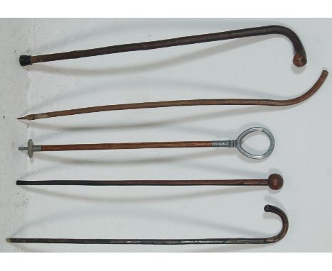 A collection of vintage wooden walking stick canes having knob handles and twist bodies together with a shooting stick. Measu