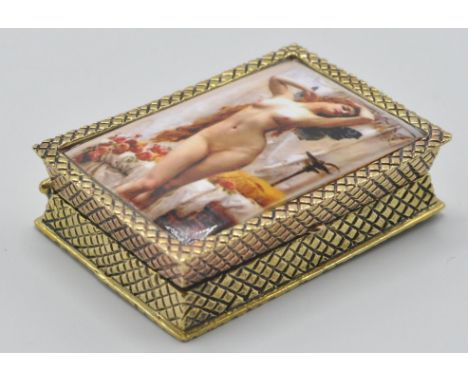 A gold plated silver ladies pill box having an enamel set erotic maiden to the top with chase decoration.