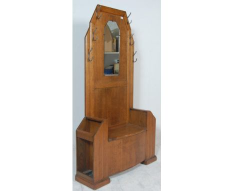 A 1930's Art Deco oak hall stand - settle bench. The hallstand with centre seat having hinged top flanked by umbrella / stick