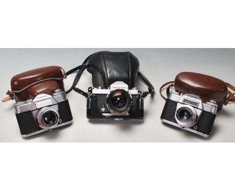 A group of three vintage 20th century 35mm photograph cameras to include a Nikkormat 35mm camera complete with a 35mm Nikkor-