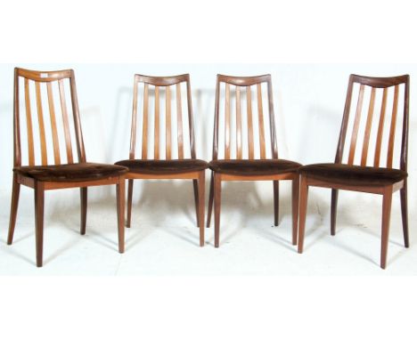 A set of four vintage retro 1970’s G plan teakwood dining chairs having brown upholstered seats with stick back rest raised o