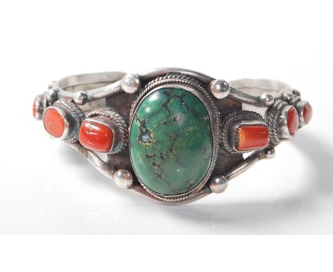 A stamped .925 silver bracelet bangle having beaded decoration to the clasp and is studded with green and red stones. Gross w
