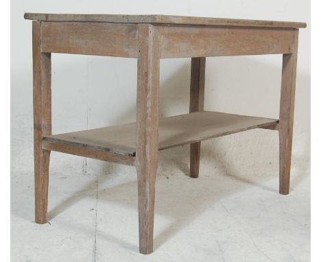 An early 20th century scrubbed top oak side / console table being raised on square tapering block legs united by undertier wi