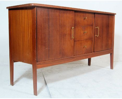 A vintage mid 20th century teakwood sideboard with oversized shaped top, bank of three drawers to the centre with brass knob 