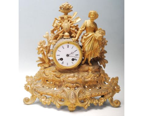 A early 20th century French brass spelter mantel clock having the typical french decoration to the body with flowers, agricul