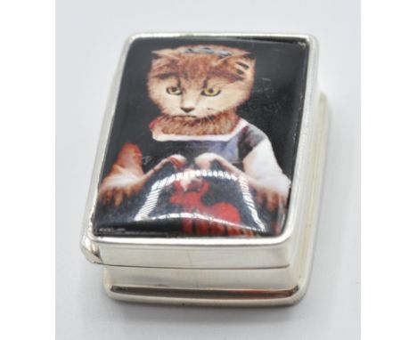 A sterling silver pill box having an enamel plaque of a cat to lid. Marked sterling. Measures: 3cm long, weight 20.8g