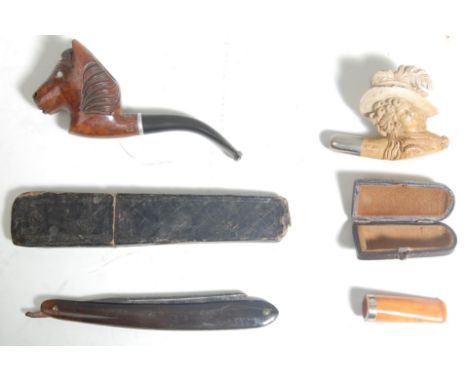 A collection of 20th century antique smoking pipes to include hand carved German black forest pipe in a shape of animal head,