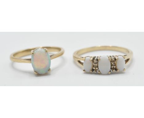 Two stamped 375 9ct gold rings to include one ring prong set with an oval opal cabochon (marked 375, size J.5) and a three st