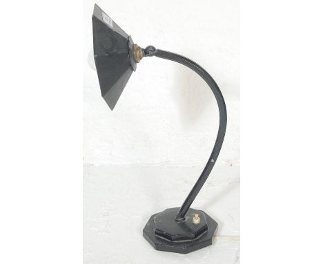 A 1920's cast metal and ebonised Industrial desk / table lamp. Raised on black octagonal base with c-scroll arm terminating i