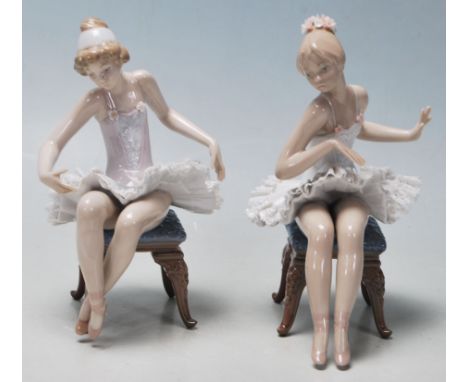 &nbsp;LLadro - A pair of late 20th Century vintage ceramic ballerinas comprising two seated girls getting ready to dance. Fin