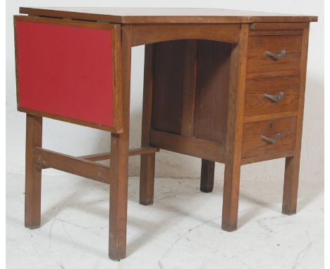 A retro vintage 1950s mid century air ministry style oak writing table / desk having a red formica top over three drawer pede