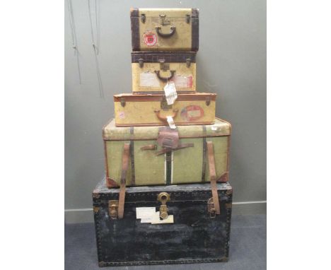 A mid 20th century travel trunk together with a travelling canvas and leather bound trunk, together with three other luggage 