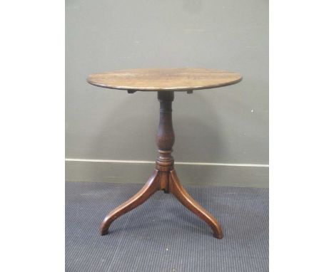 A 20th century oak tripod table, the circular top above a turned pillar and three down swept legs 69cm high and 66cm diameter