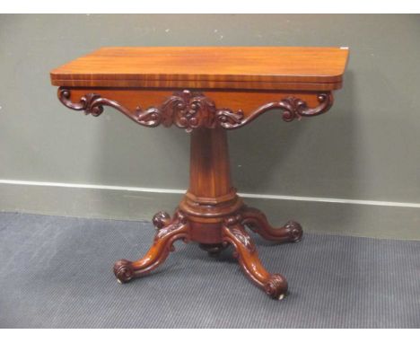 A William IV mahogany card table on chamfered column and acanthus leaf carved scroll legs on white ceramic castors 75 x 92 x 