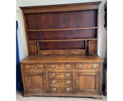 An 18th North Wales oak dresser, the rack with a moulded cornice, two shelves, two cupboards and three drawers, the base with
