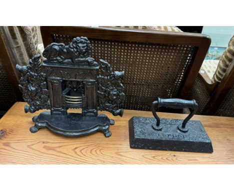 A miniature cast iron fireplace with a lion surmount and miniature grate on a shaped base with lions paw feet together with a