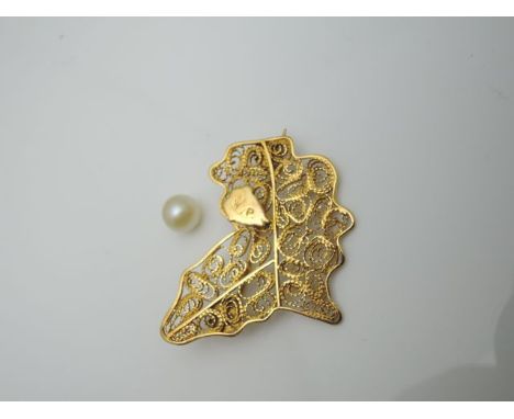An unmarked gold brooch, in the form of Africa, with wire work decoration, Nigeria highlighted with an initialled plaque, 4,3