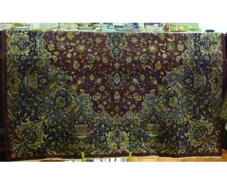A Persian style wool carpet with plum coloured ground, with abstract floral detail and further floral borders