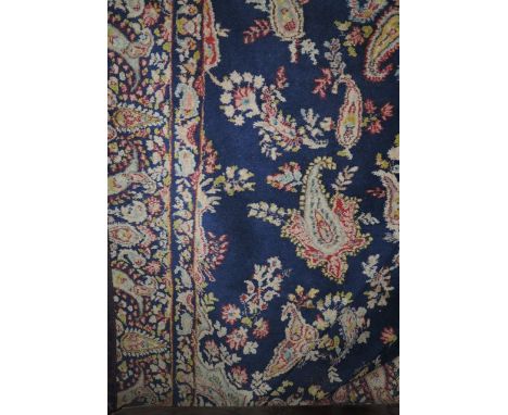 A Persian style wool carpet, the central medallion on a dark blue field with abstract floral detail and set within running bo
