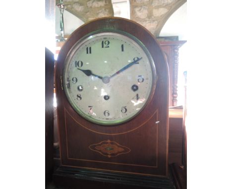 An Edwardian mantle clock with arched casework and inlaid detail, the circular dial enclosing a three train movement with sil