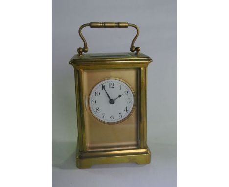 A French carriage clock, the brass case enclosing a circular enamelled dial and eight day timepiece