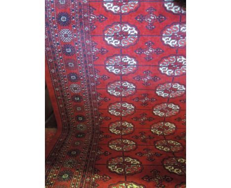 A red ground Persian style wool carpet with multi-medallion centres within running borders