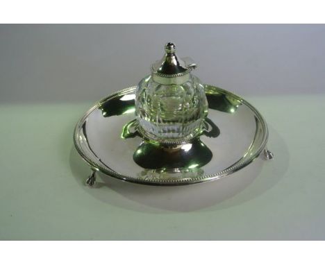 A Victorian silver inkwell, Sheffield, 1877, the circular base on three paw feet, with beaded rim, centred with the removable