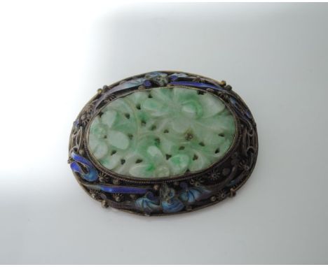 A silver gilt Chinese brooch, centred with an oval carved jade plaque, the border highlighted with two enamelled bats and scr