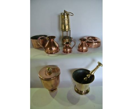 A selection of copper wares to include two ring shaped jelly moulds, one marked M, a trio of graduated copper flagons, a copp