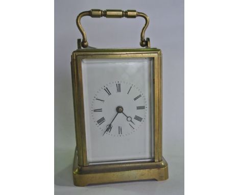 A brass carriage clock of simple form with enamelled dial and eight day timepiece