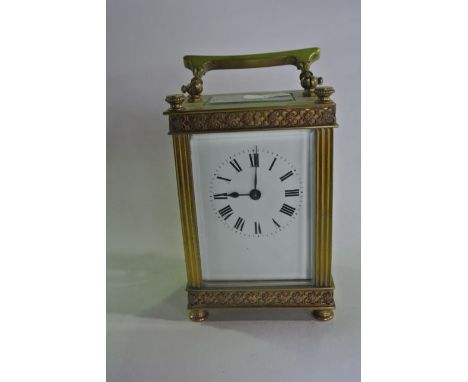 A small French carriage clock with decorative casework, enamel dial and eight day timepiece