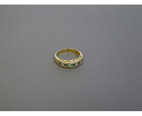 An 18ct gold emerald and diamond half eternity ring