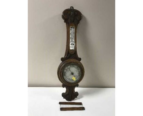 A carved oak banjo barometer
