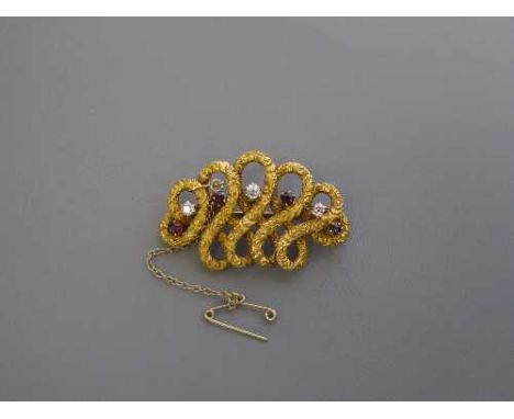 A 14ct gold diamond and ruby swirl brooch, 10.2g, 45mm