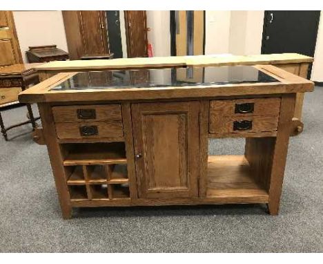 A contemporary oak kitchen work bench with black granite top