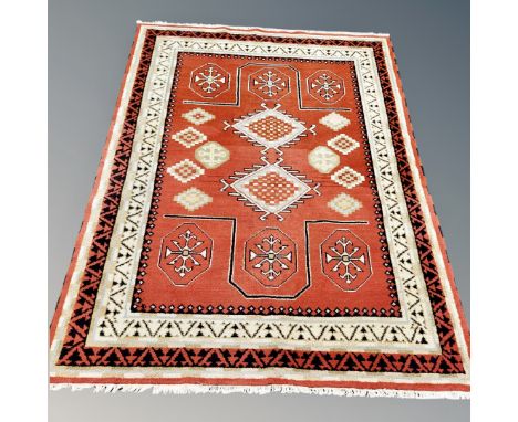A contemporary Eastern style carpet on red ground, 246 cm x 175 cm 