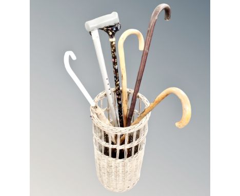 A wicker stick basket of walking sticks and umbrella 